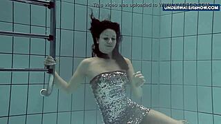 A Russian woman in a bikini at a nudist beach shows off her big boobs while swimming and arouses the desire of everyone around her