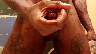 Black man with a large penis pleasuring himself
