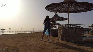 Beautiful young girl flashes big tits and ass without panties on public beach.