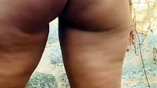 Village girl plays with herself behind house in open air