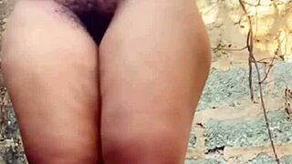 Village girl plays with herself behind house in open air