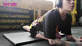 an alternative girl with tattoos stretches her young body during a sexy session at the gym