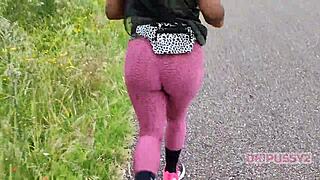 ebony with big ass in leggings runs alone in nature, showing off tattoo and prostitute vibe boldly.