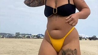 young african girl on usa beach wears tight yellow bikini to show swollen pussy and draw attention