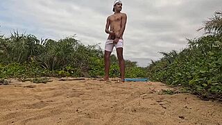 African dude jerks off and cums on beach