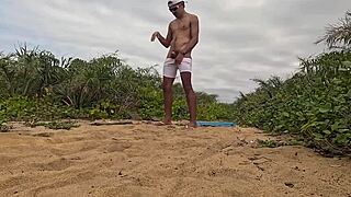 African dude jerks off and cums on beach