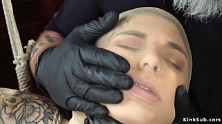 tattooed sub in bamboo bondage suspension with gagging